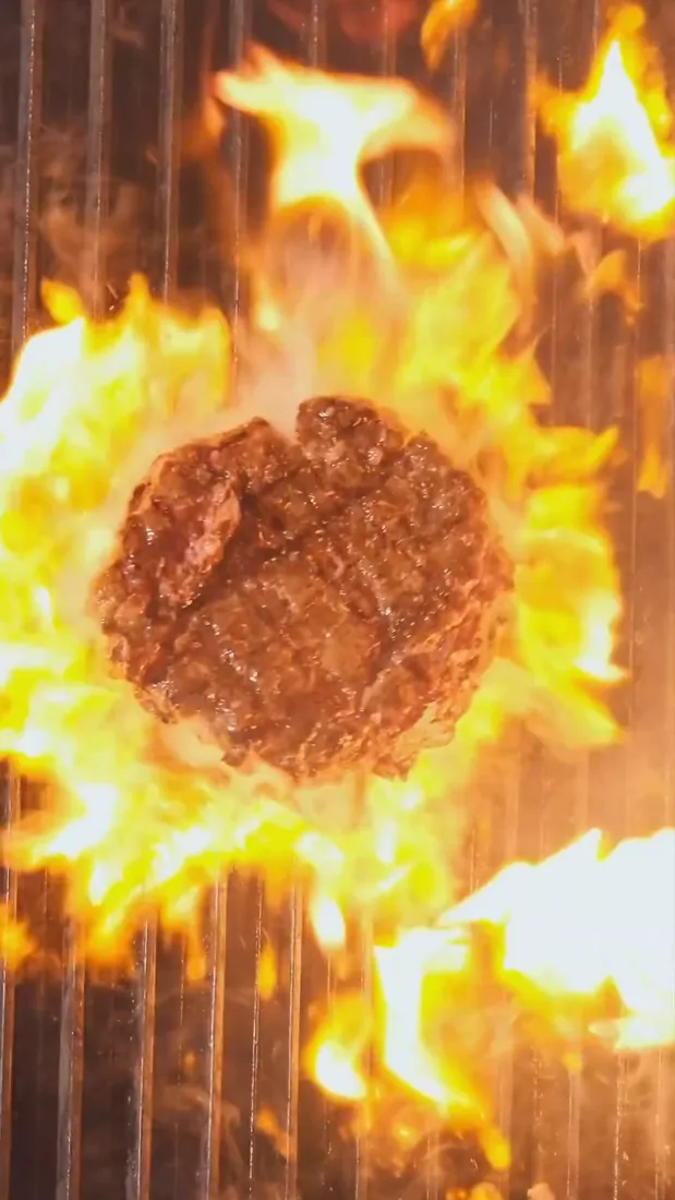 Burger patty flamed on the grill
